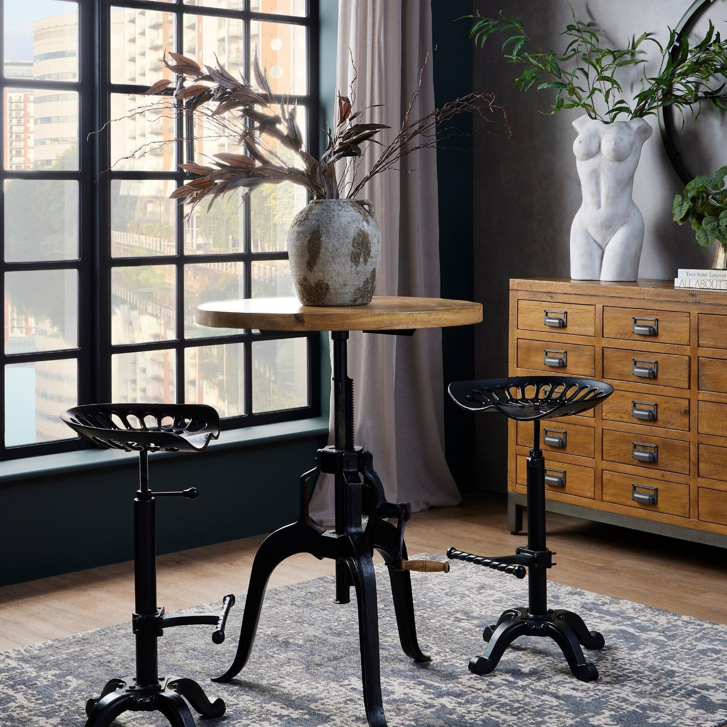 Black metal Dine and Dwell Norwich adjustable tractor bar stool with a sleek modern design.