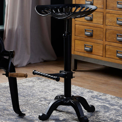 Black metal Dine and Dwell Norwich adjustable tractor bar stool with a modern design and ergonomic seat.