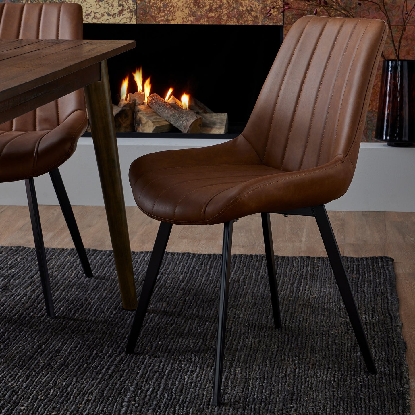 Wareham Tan Faux Leather Dining Chair by Dine and Dwell with channel stitching and black metal legs, showcasing stylish modern design.
