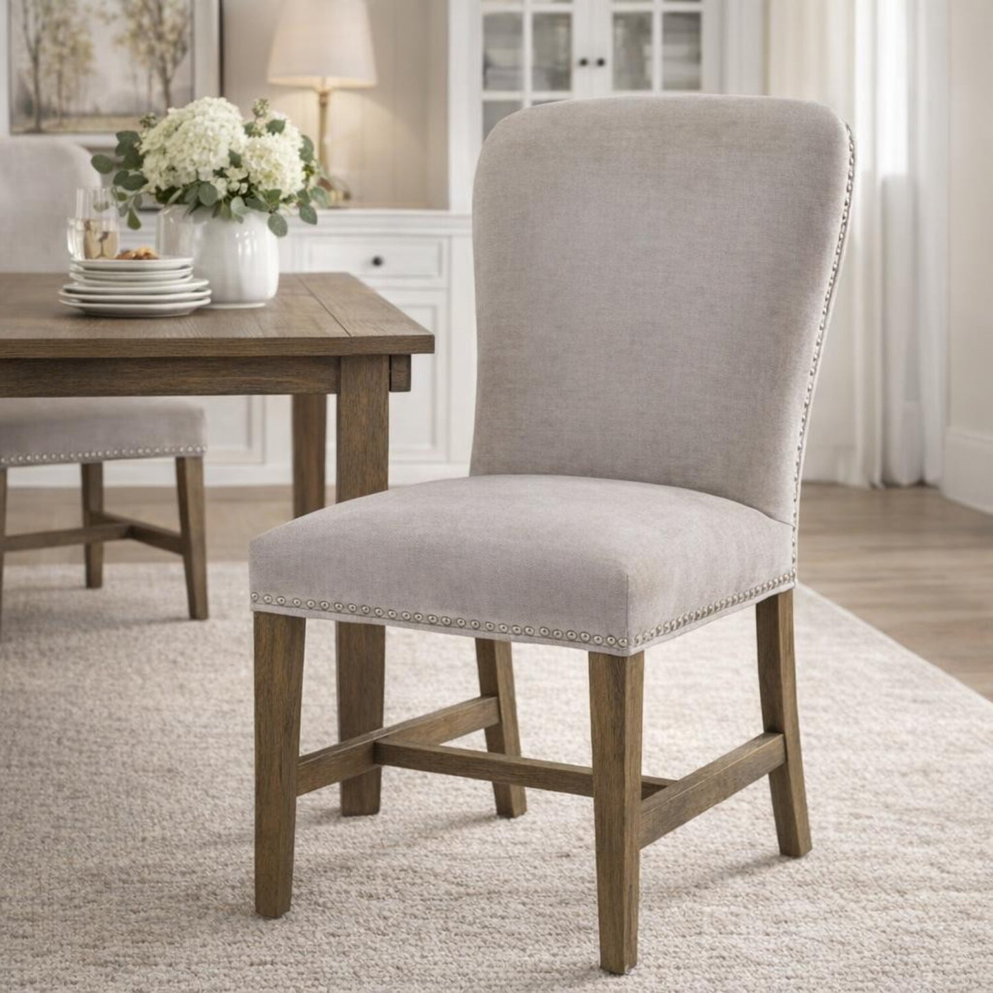 Winchester grey upholstered dining chair with oak frame and brass studding, stylish Dine and Dwell dining room seating.