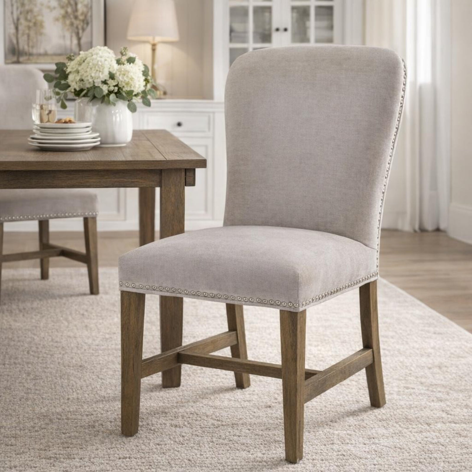 Winchester grey upholstered dining chair with oak frame and brass studding, stylish Dine and Dwell dining room seating.