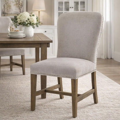 Winchester grey upholstered dining chair with oak frame and brass studding, stylish Dine and Dwell dining room seating.