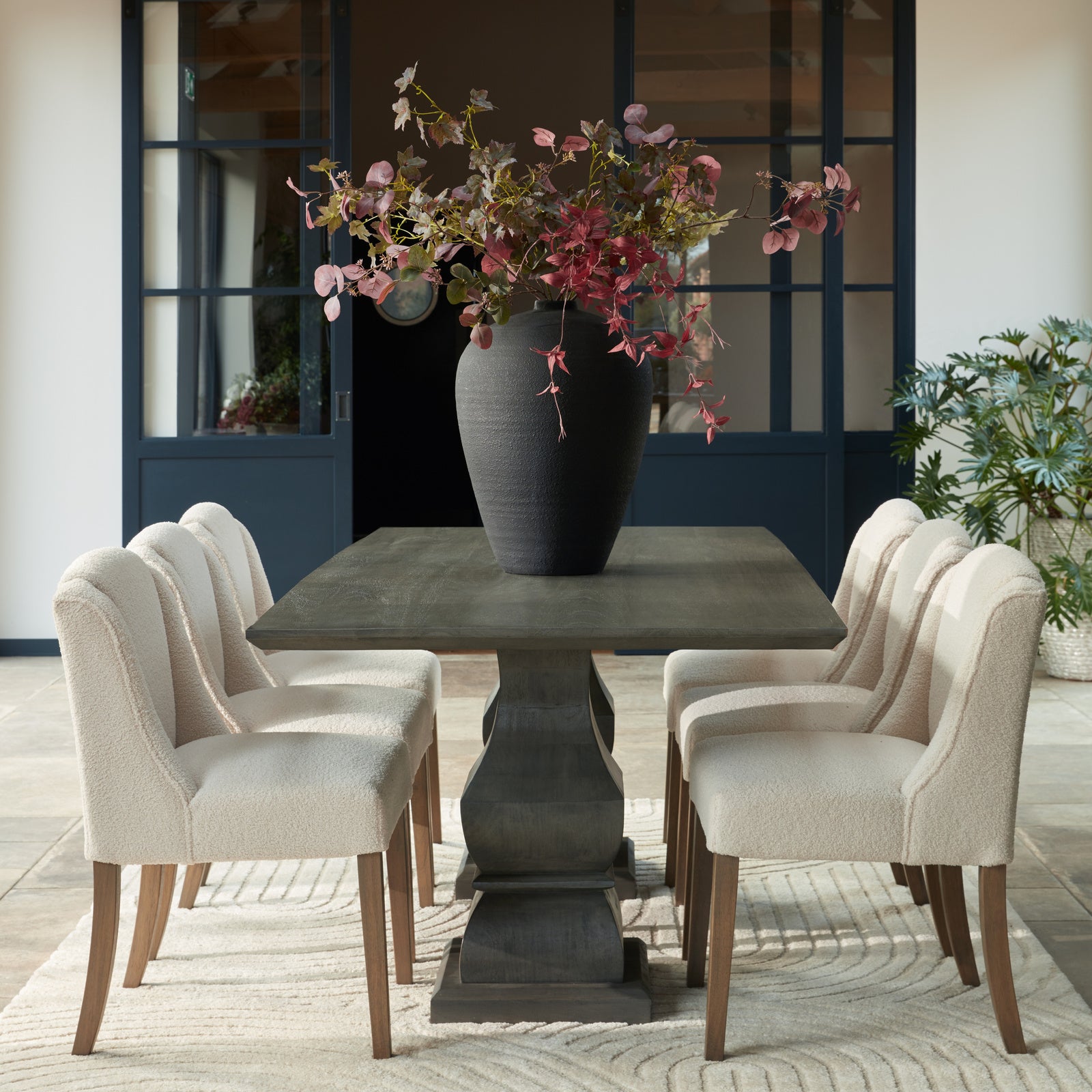 Cream upholstered Dine and Dwell Bristol Boucle dining chair with wooden legs, showcasing a stylish and comfortable seating option.