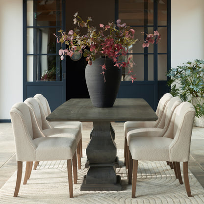 Cream upholstered Dine and Dwell Bristol Boucle dining chair with wooden legs, showcasing a stylish and comfortable seating option.