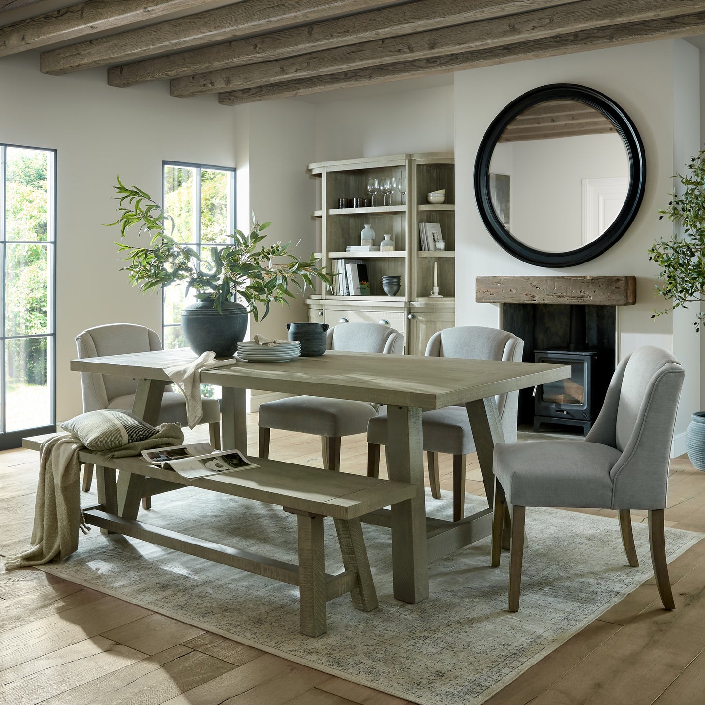 Grey upholstered Dine and Dwell Bristol dining chair with wooden legs, shown from a side angle.