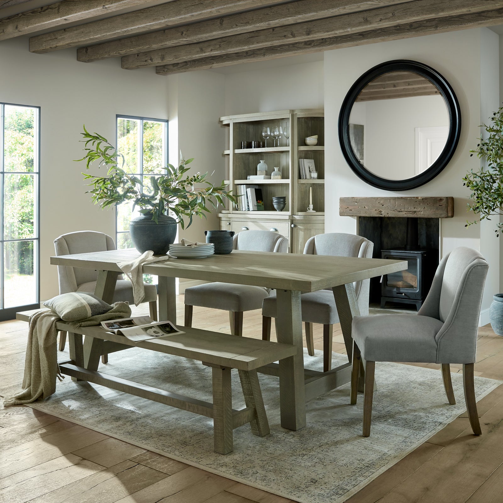 Grey upholstered Dine and Dwell Bristol dining chair with wooden legs, shown from a side angle.