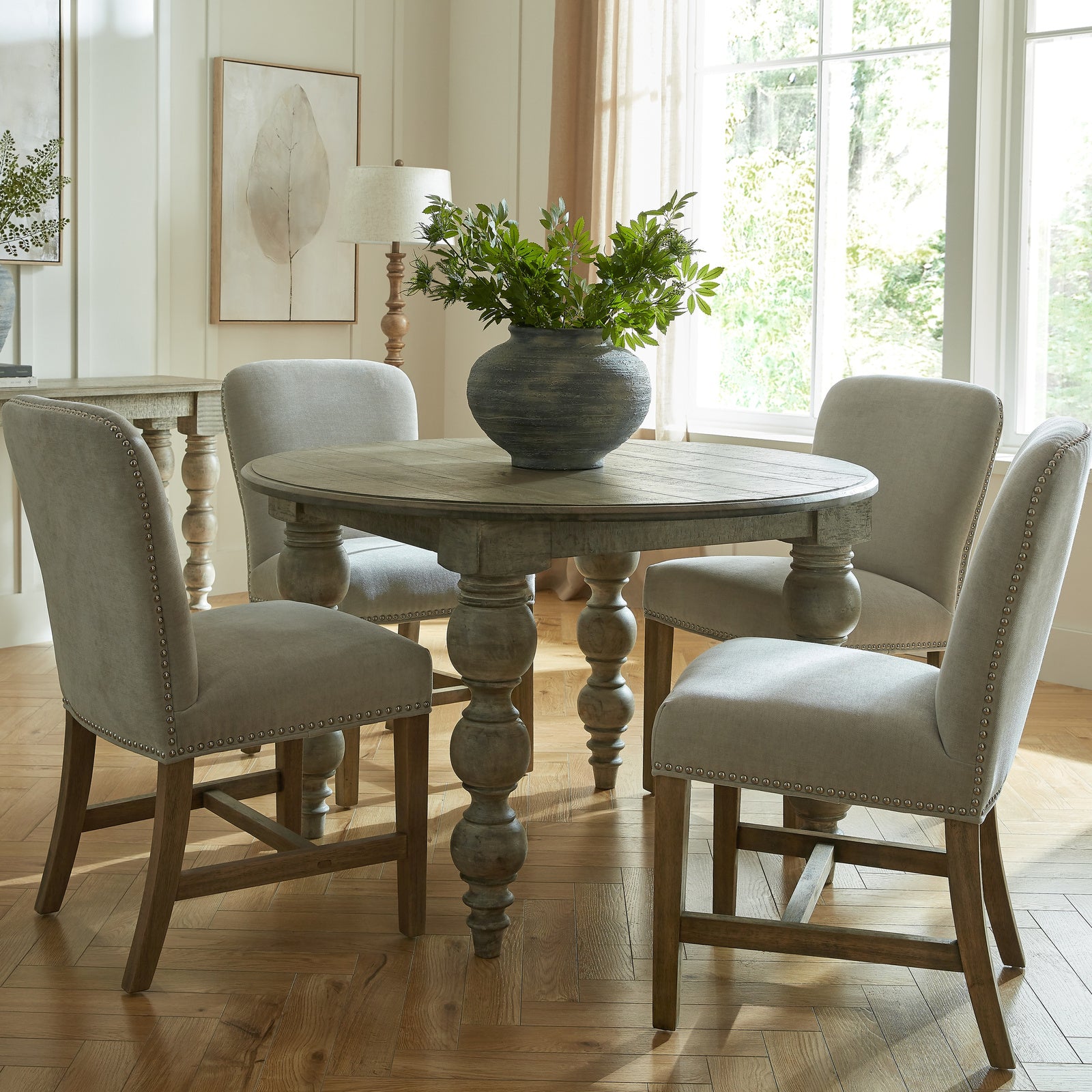 Round brown wood dining table by Dine and Dwell with sleek design and sturdy legs, ideal for modern dining spaces.