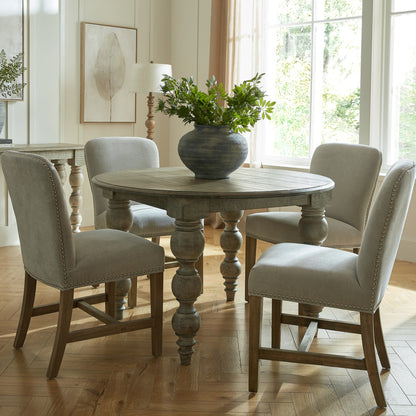 Round brown wood dining table by Dine and Dwell with sleek design and sturdy legs, ideal for modern dining spaces.