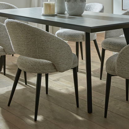 White upholstered Dine and Dwell Sandwell curved dining chair with black metal legs, modern and stylish for dining rooms.