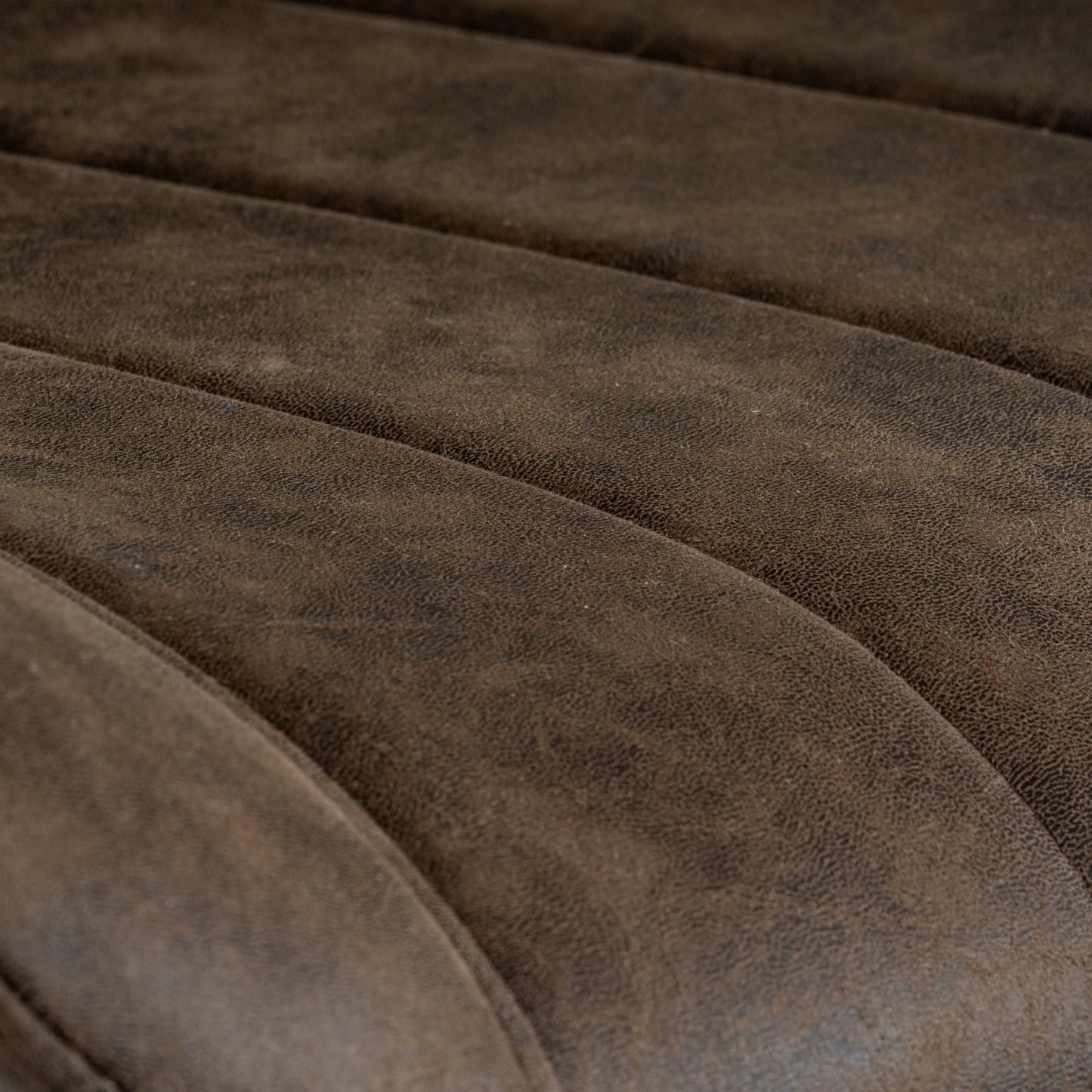 Wareham coffee swivel dining chair by Dine and Dwell with leather-effect fabric, channel stitching, and black metal base.